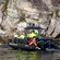 A rigid inflatable boat filled with passengers navigating toward a waterfall